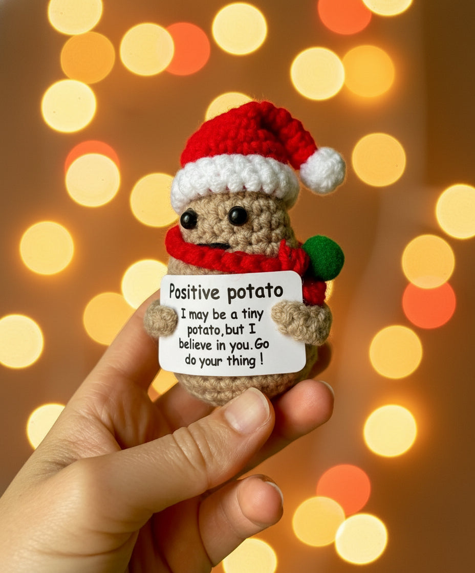 Positive Potato Weihnachts-Edition in der Hand gehalten mit Lichterketten in dem Hintergrund