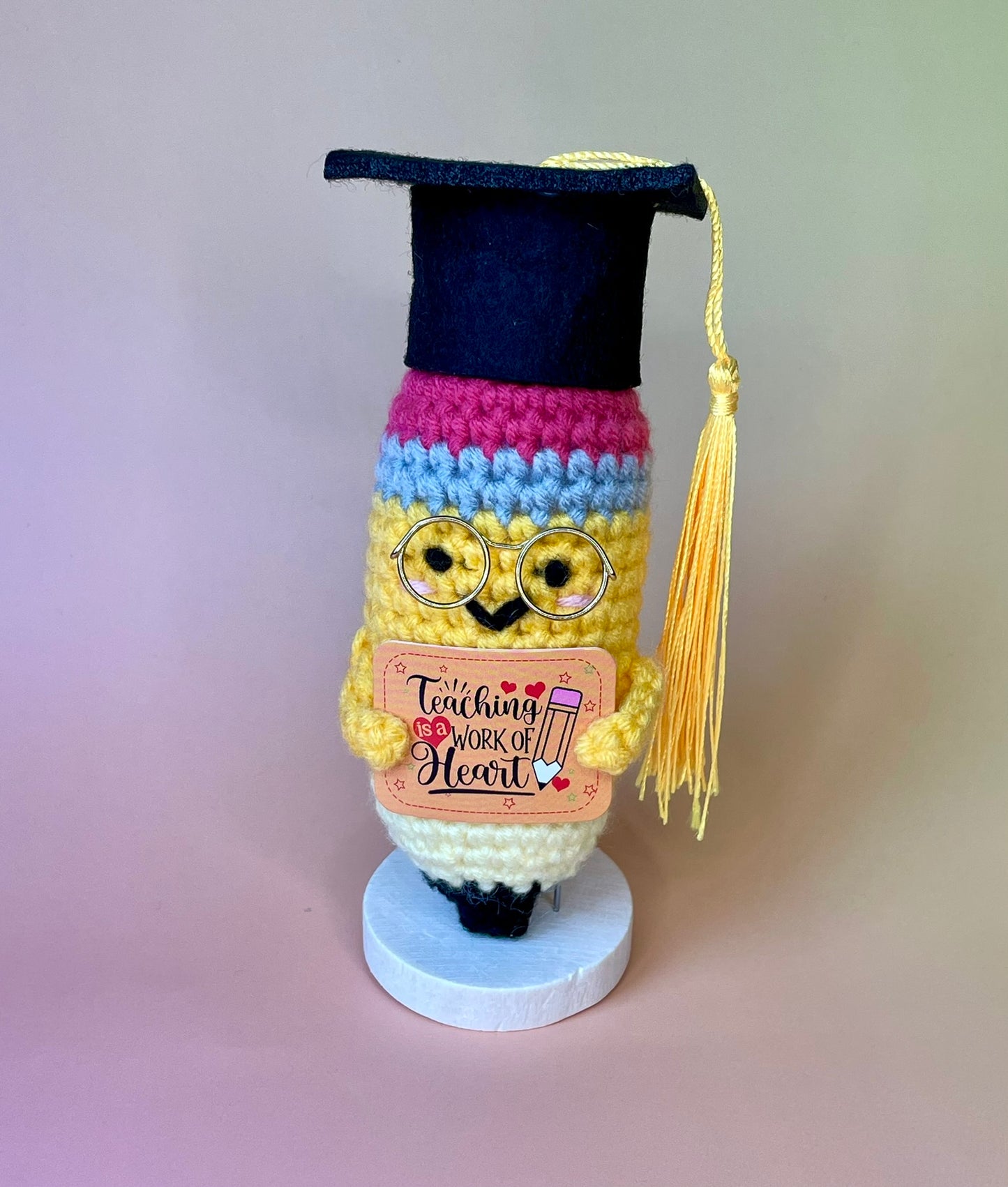 Gehäkelte Bleistift-Figur mit Diplomhut – seitliche Ansicht auf Holzsockel, personalisiertes Geschenk für Lehramt