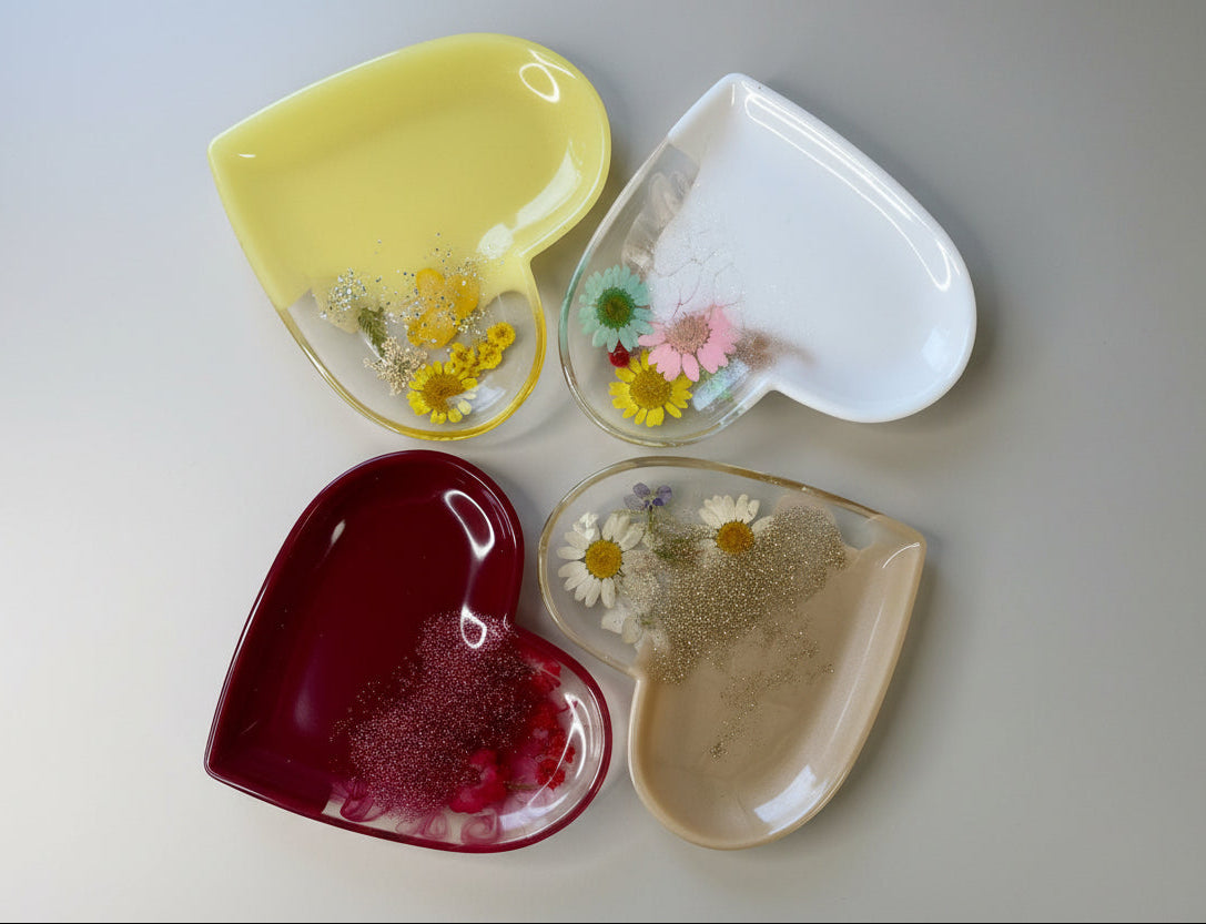 Herzförmige Schälchen aus Epoxidharz mit echten Blumen in verschiedenen Farben - Ansicht von oben