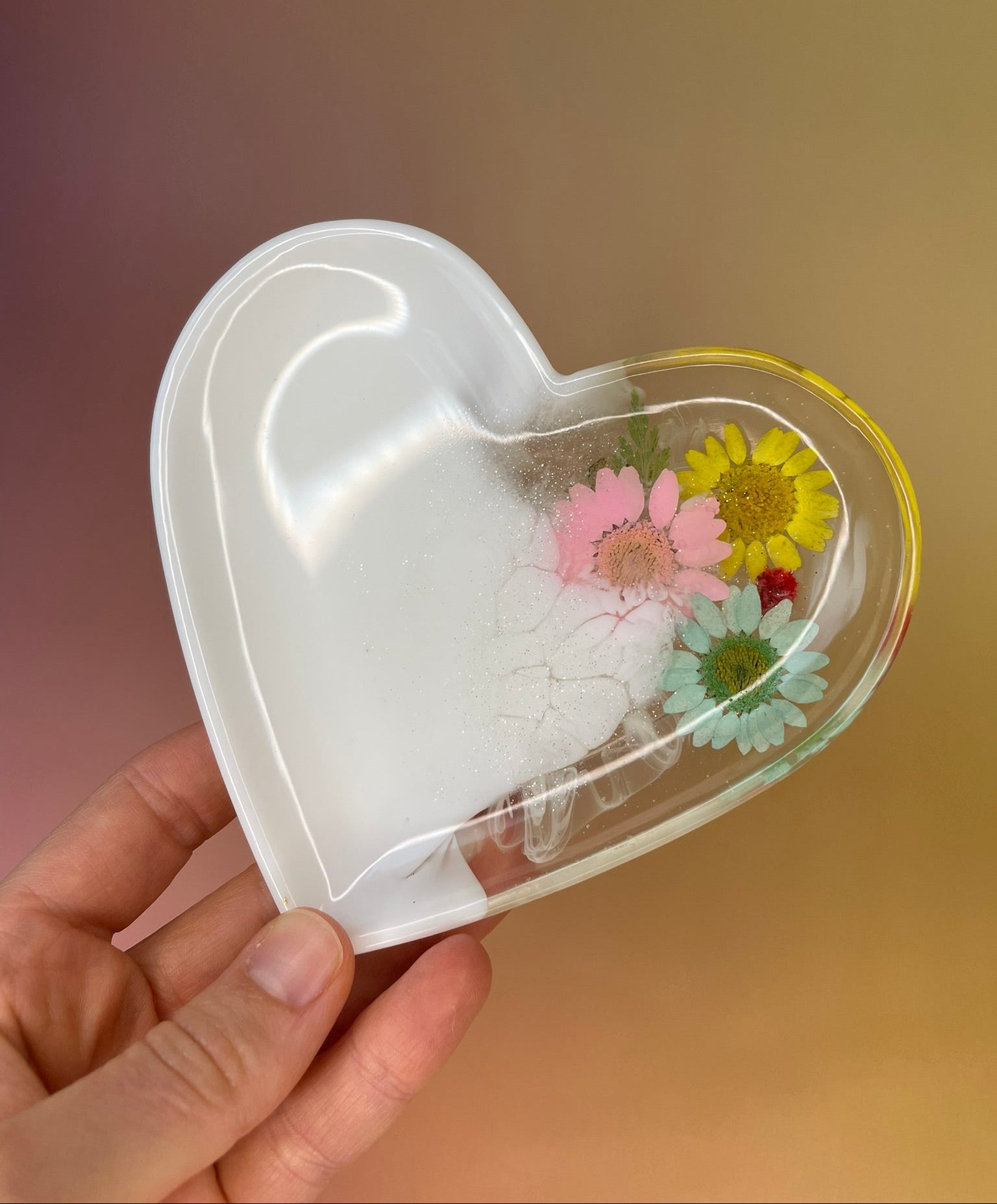 Weiße handgemachte Herz-Schmuckschale aus Epoxidharz mit leichtem Glitzer und echten Blüten 