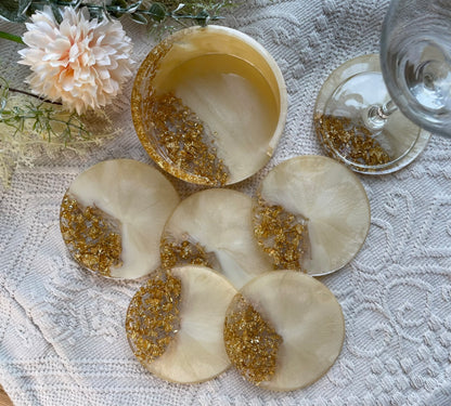 Detailansicht Resin Untersetzer Champagne Gold - 6 runde Untersetzer mit schimmernden Goldflocken und elegantem Halter, dekoriert mit Blumen
