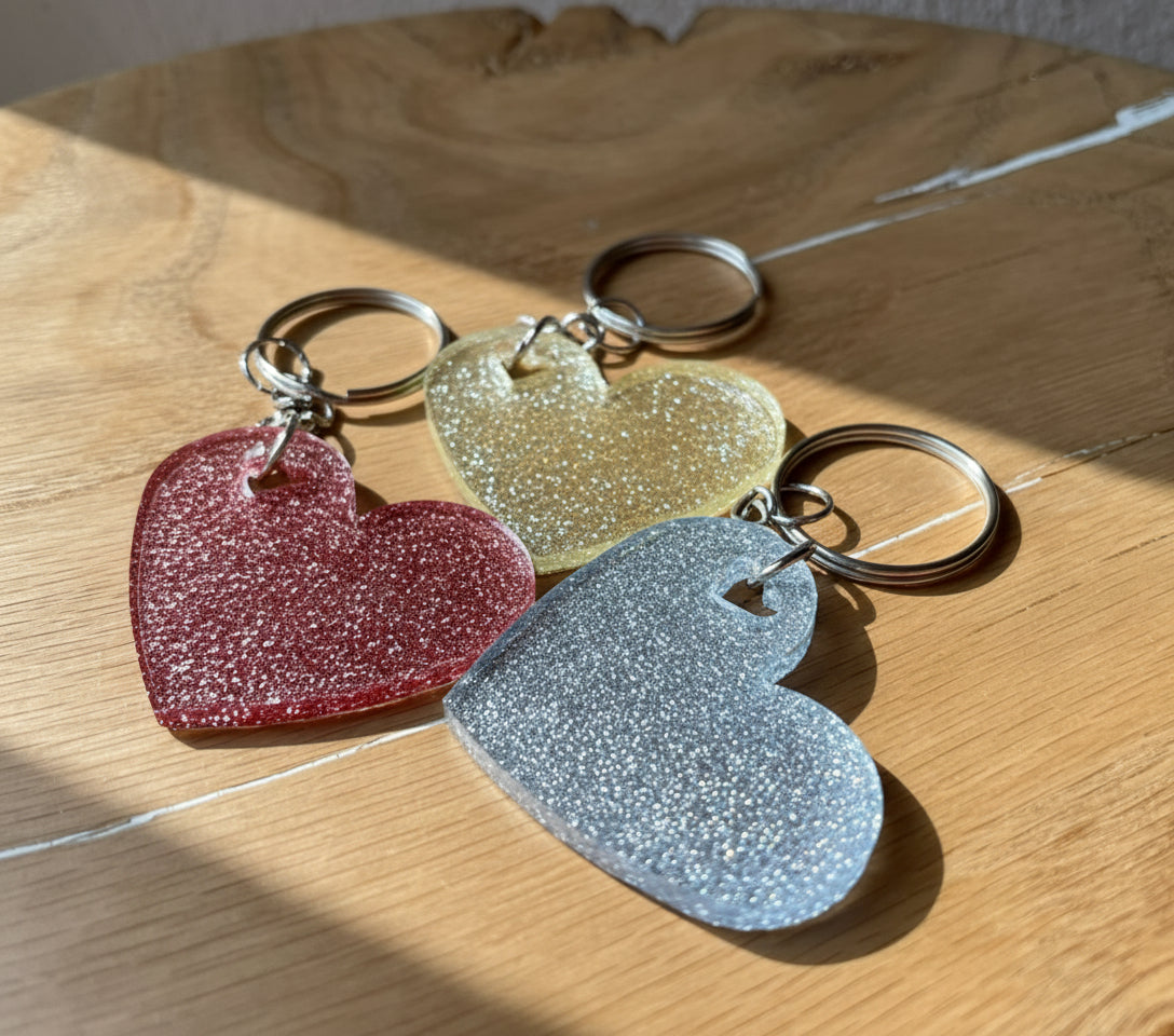 Drei Stück herzförmige Epoxidharz Schlüsselanhänger - in Rosa Glitzer, Silber-Glitzer, und Champage-Glitzer Farben.