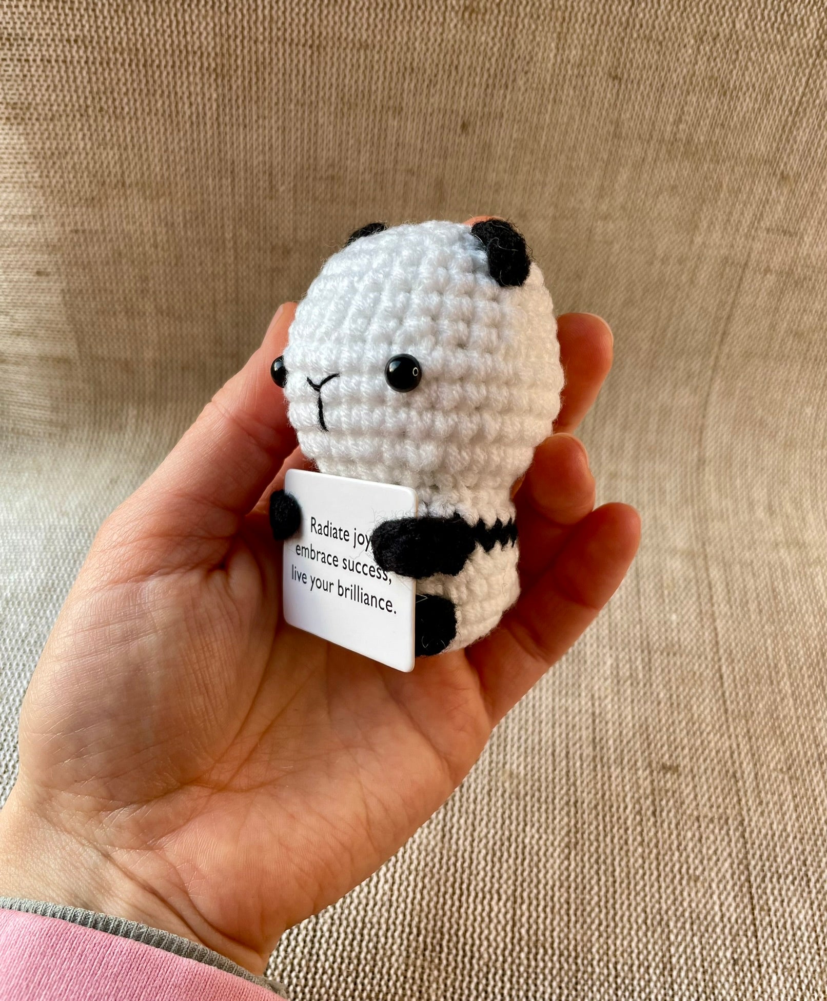 Positive gehäkelte Panda in der Hand gehalten 