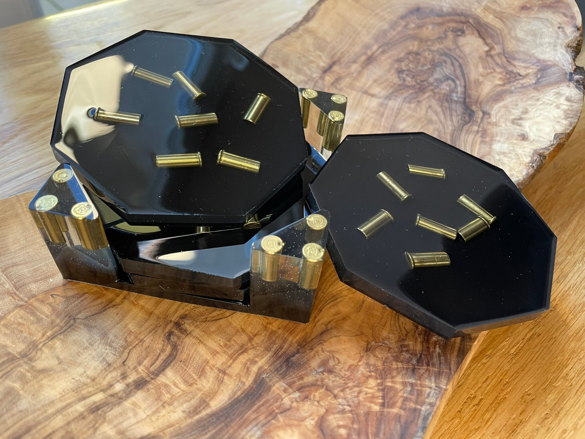 Epoxidharz Untersetzer Set Schwarz mit Metall-Hülsen, 5-teilig, auf einem Holztisch fotografiert