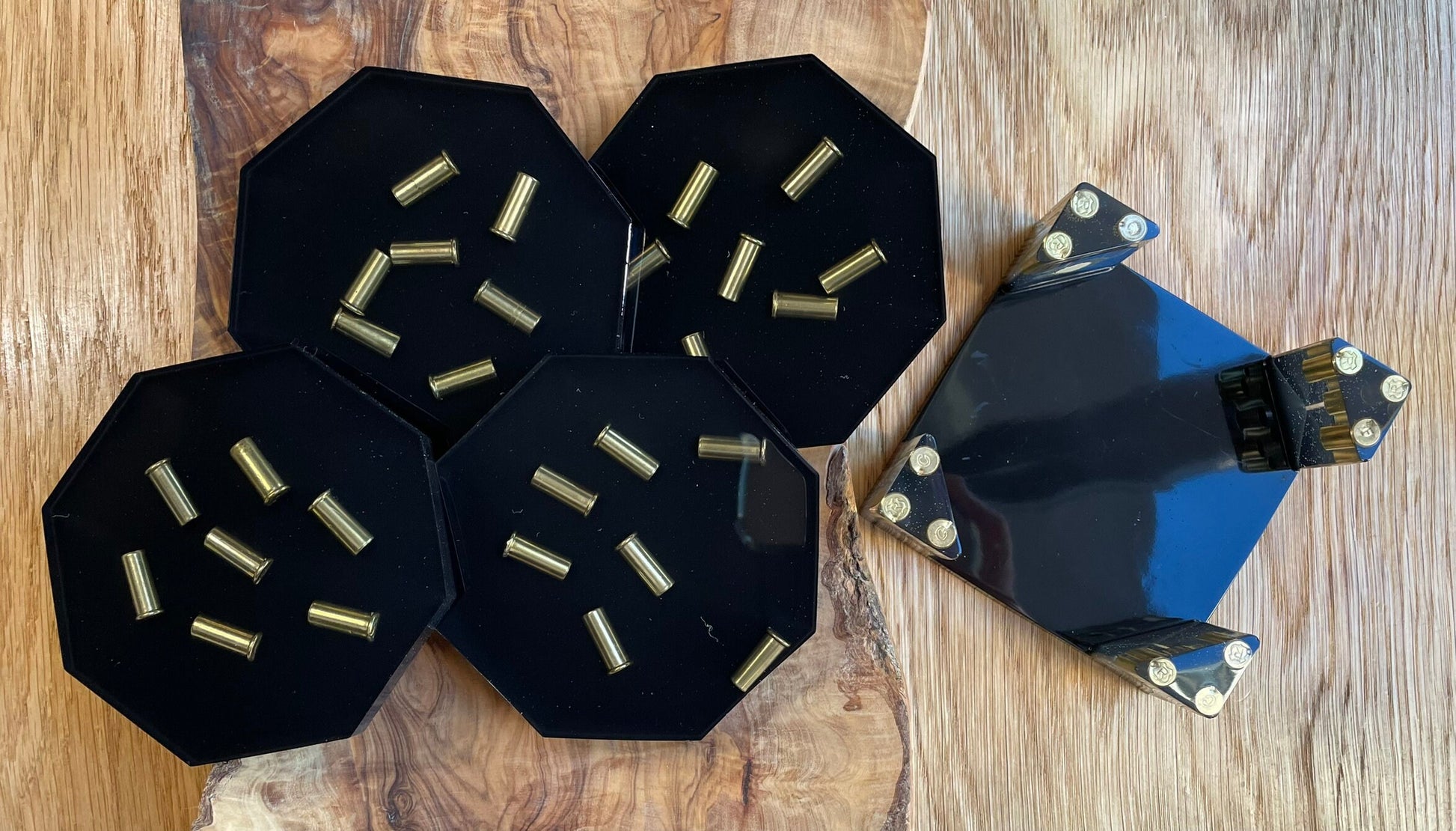 Epoxidharz Untersetzer Set Schwarz mit Metall-Hülsen, 5-teilig, auf einem Holztisch von oben fotografiert.